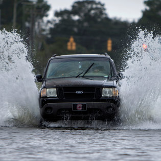 A motorist driving through seawater in Charleston, S.C., last year. In the decade from 1955 to 1964, Charleston registered 34 days with flooding; in the decade from 2005 to 2014, the number jumped to 219.